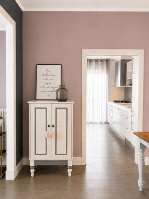 A kitchen with a cabinet, a framed quote, and a view into the dining area. - Cozy, newly renovated apartment in Alassio with private garage (alassio)