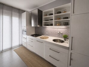 A modern kitchen with white cabinetry, a stainless steel sink, and a tiled backsplash. - Cozy, newly renovated apartment in Alassio with private garage (alassio)