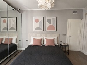 A modern bedroom with a bed, bedside tables, and artwork on the wall. - Cozy, newly renovated apartment in Alassio with private garage (alassio)