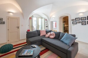 A modern living room with a grey sectional sofa, a round coffee table, and a striped rug.