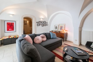 A modern living room with a sectional sofa, a coffee table, and artwork on the walls.