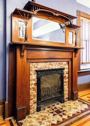 A fireplace with a decorative mantel and a tiled floor.