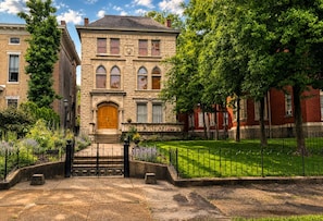 A historic building with a stone facade, arched windows, and a central entrance with a wooden door.