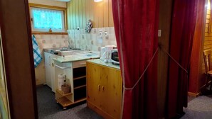 A compact kitchen with a stove, microwave, and coffee maker. - Cozy vacation home in the countryside (Prenzlau)