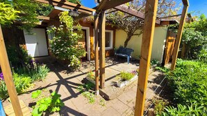 A garden with a pergola, potted plants, and a bench. - Cozy vacation home in the countryside (Prenzlau)