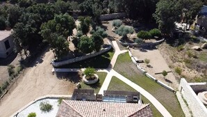 An aerial view of a landscaped area with pathways, trees, and a water feature.