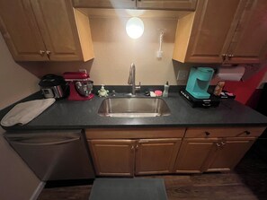A kitchen with a sink, countertop, and wooden cabinets. - Perfect 1-bedroom apartment in Anchorage for a cozy getaway (Anchorage)