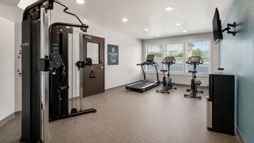 A fitness center with a weight machine, treadmills, and an elliptical.