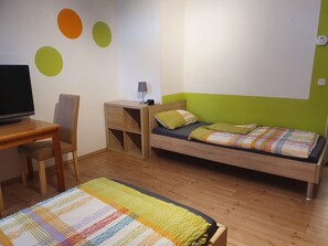 Une chambre à coucher comprenant un lit, un bureau, une chaise et un téléviseur.