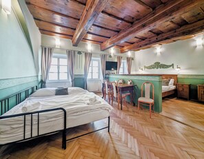 A room with a bed, a desk, a chair, and a television. - Apartments Kajovska (Ceský Krumlov)