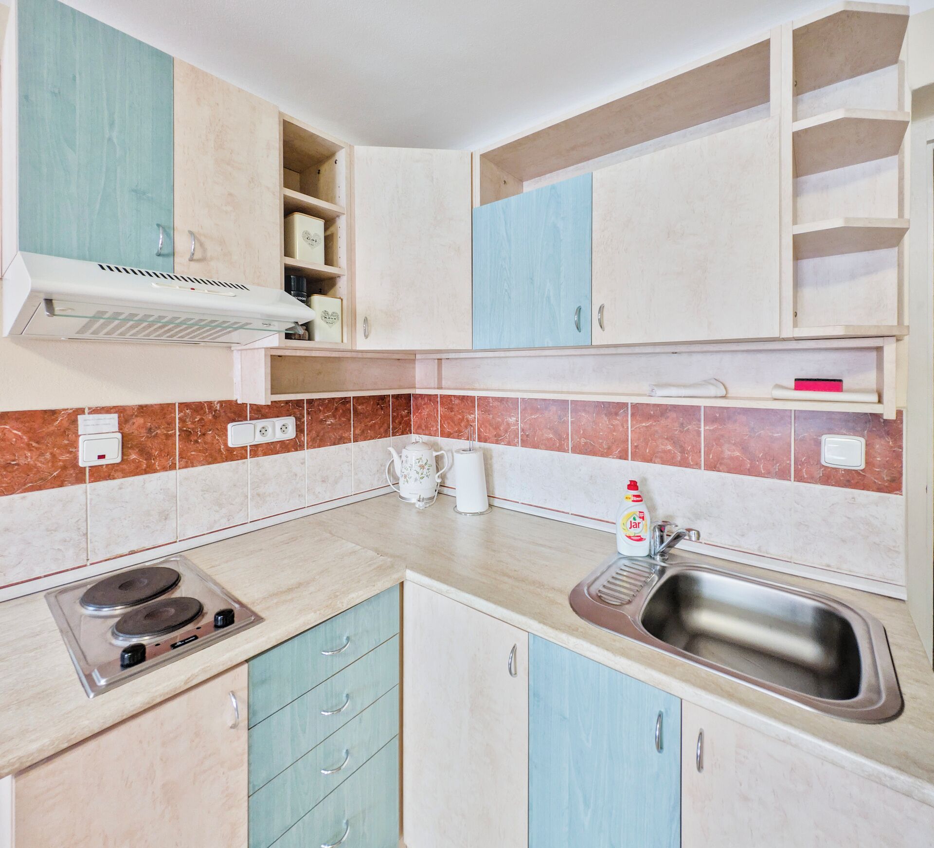 A kitchen with a gas stove, a sink, and cabinets.