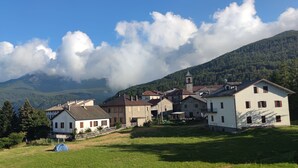 En landsby med traditionelle huse, en kirke og et bjerg i baggrunden.