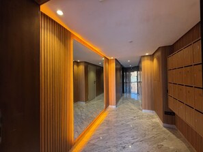 A hallway with wooden paneling, a marble floor, and a row of lockers on the right. - Cosy apartment in the center of Marrakech (Marrakech)