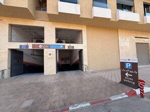 A building entrance with a parking sign, a Carrefour market sign, and a Carrefour LabelVie sign. - Cosy apartment in the center of Marrakech (Marrakech)
