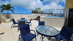 Une terrasse sur le toit avec une piscine, des espaces de détente en plein air et une vue sur le panorama urbain.