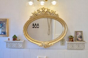 A bathroom with a large ornate gold-framed mirror, a white tiled wall, and a shelf with decorative items. - Fairytale Castle• Hot Tub •Sleeps 10• By WORLD CUP & Downtown Atlanta (Atlanta)