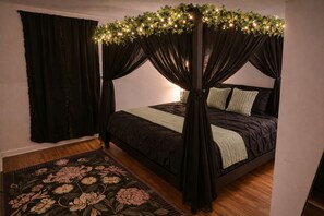 A bedroom with a four-poster bed, a floral-patterned rug, and a dark-colored canopy. - Fairytale Castle• Hot Tub •Sleeps 10• By WORLD CUP & Downtown Atlanta (Atlanta)