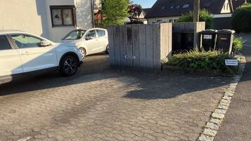 A gated parking area with a 'Privat' sign, a white car, and a building with a 'SULC' sign.