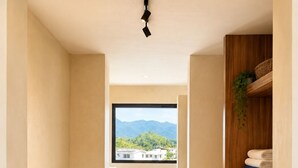 A narrow hallway with a window, a plant, a shelf, and a laundry area. - Boutique apartment with ocean view, pool, 2 blocks from the beach! (Rincón de Guayabitos)