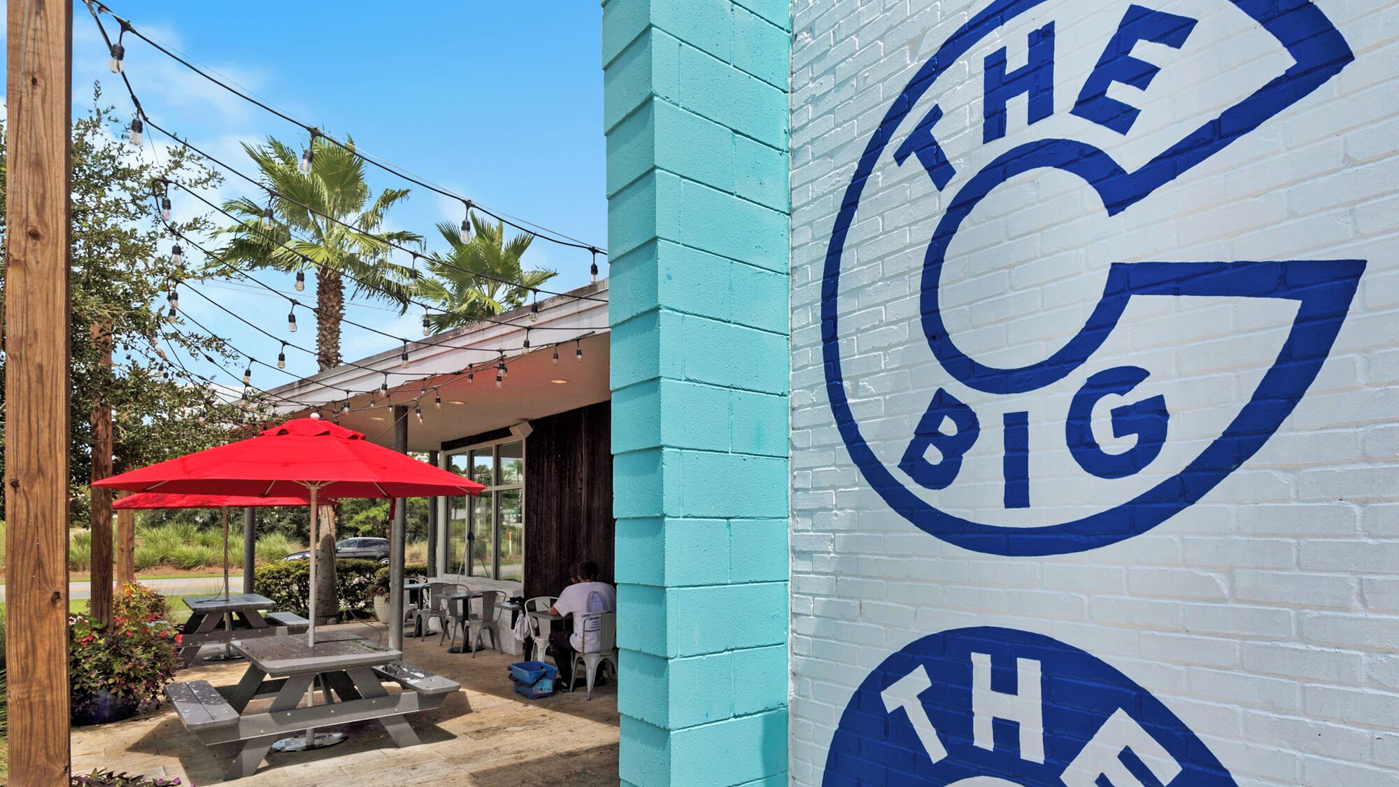 A building with a blue and white wall featuring a large blue logo with the text 'THE BIG'.