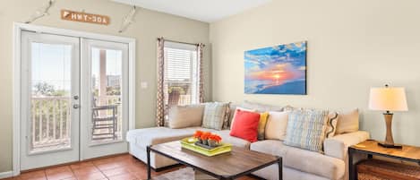 A living room with a sofa, a coffee table, a lamp, and a painting.