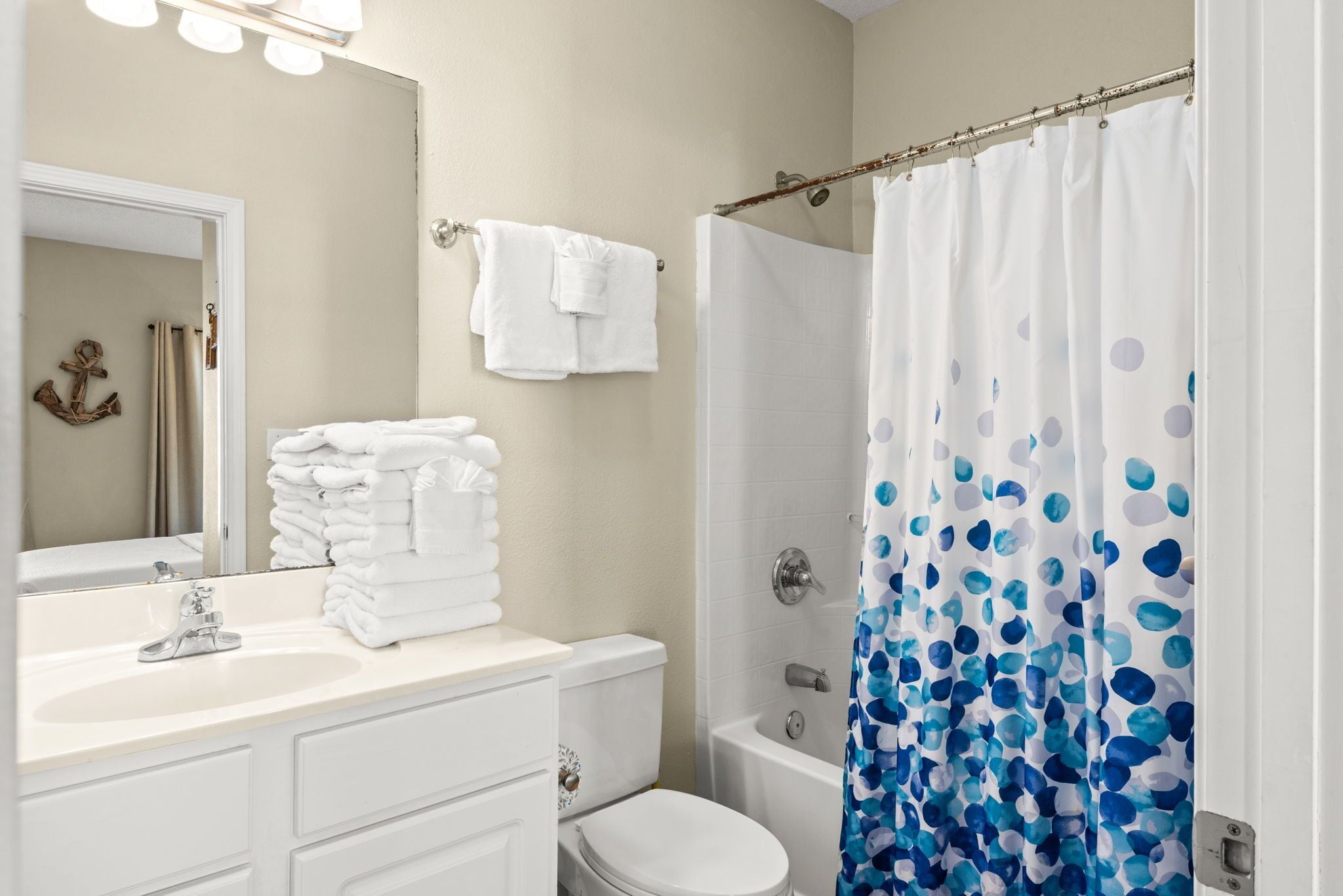 Un baño con lavamanos, inodoro y cortina de ducha.