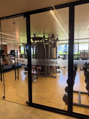 Ein Fitnessstudio mit Herz-Kreislauf-Geräten, Krafttrainingsmaschinen und Laufbändern.