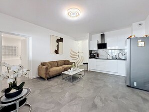 Eine moderne Wohnung mit Wohnzimmer, Küche und Essbereich.
