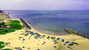 Una platja amb barques i un bascul protector rocos.