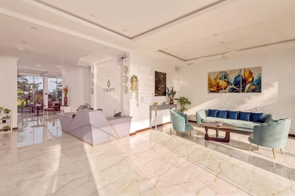 Un amplio vestíbulo con mostrador de recepción, zona de estar y vistas al comedor.