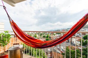 A hammock on a balcony with a city view. - Apartamento vista panorámica oeste seguro central (Cali)