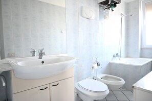 Un baño con lavamanos, inodoro, bidé y bañera.