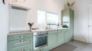 Una cocina equipada con estufa, horno, pileta y alacenas.