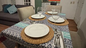 A dining area with a table set for four, a sofa, and a kitchen in the background. - Completely private property GDL (Zapopan)