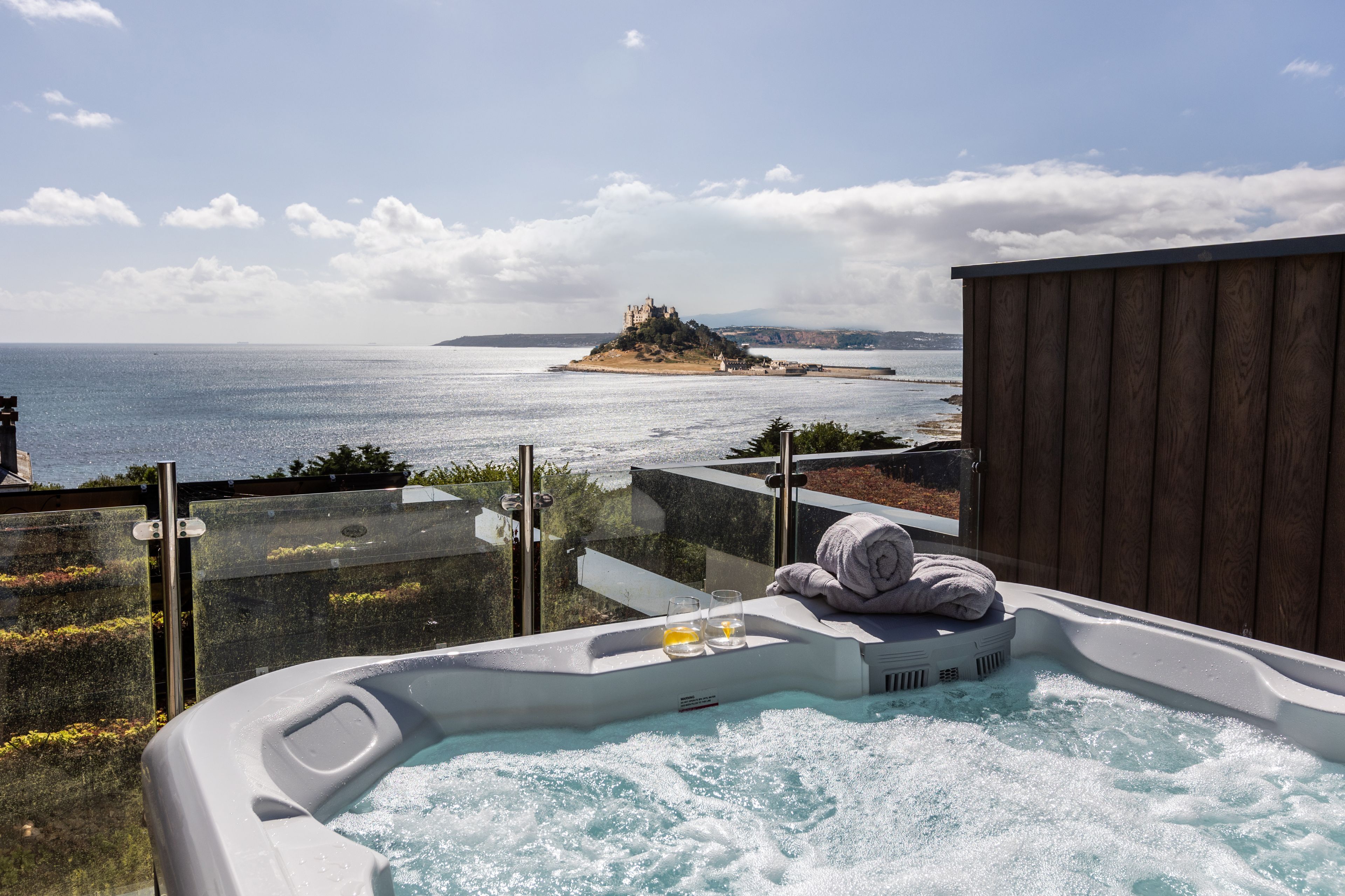 Jacuzzi con una toalla, con vistas a la costa y un castillo en una isla.