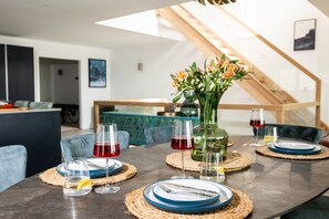 A dining table set with plates, glasses, and a vase with flowers.