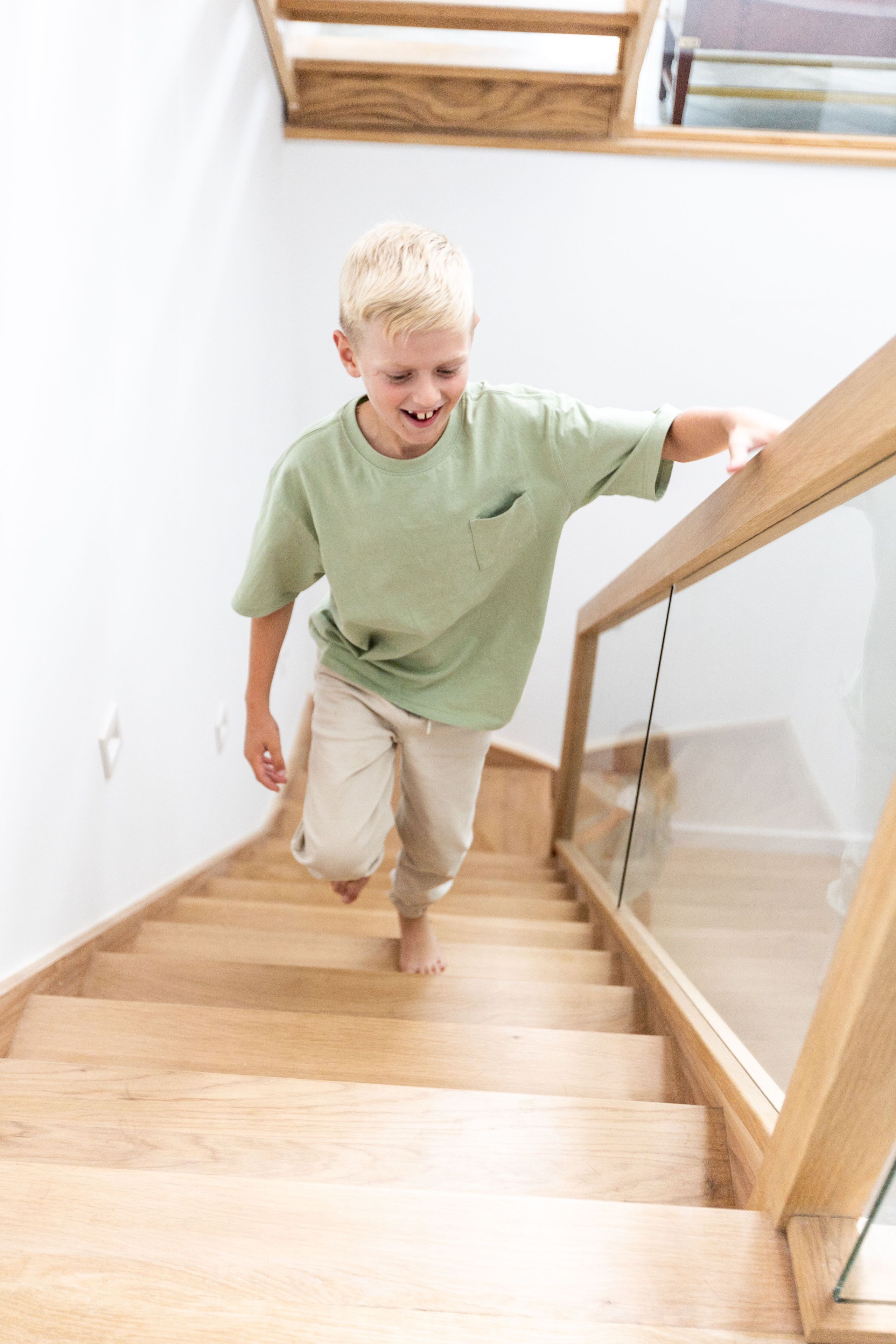 A staircase with wooden steps and a glass railing.