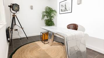 Een kamer met een op een statief gemonteerde camera, een ingelijste foto aan de muur, een kamerplant en een stoel.