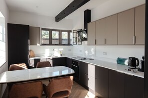Eine moderne Küche mit Essbereich, Einbauküche und großem Fenster.
