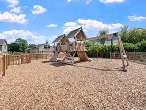 A playground with wooden structures, a swing set, and a wooden fence. - Wood-Fired Hot Tub & Pub Couples Retreat (Osmington, Weymouth)