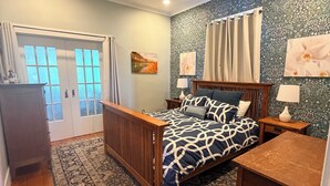 A bedroom with a bed, a ceiling fan, a nightstand, a dresser, a rug, and a window with curtains. - Historic updated 2-bedroom bungalow in a walkable neighborhood (Tucson)