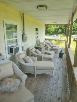 A covered porch with wicker furniture and potted plants. - 2-bedroom house in perfect Morehead City with AC (Morehead City)