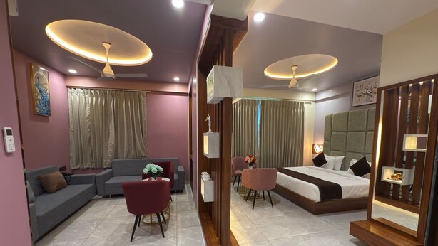 Une chambre d’hôtel moderne équipée d’un canapé, d’une table à manger, d’une chaise, d’un lit et d’un miroir.
