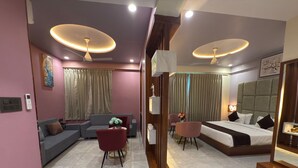 Une chambre d’hôtel moderne équipée d’un canapé, de fauteuils, d’un lit et d’un coin repas.