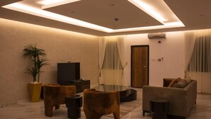 Una sala de estar moderna con un televisor de pantalla plana, una mesa de centro de vidrio y un sofá.