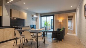 Une cuisine moderne avec un coin repas, un canapé et une vue sur l’extérieur.