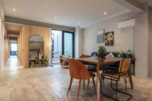 Ein modernes Interieur mit Essbereich, Holzboden und einem großen Fenster.