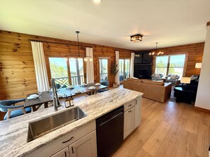 A modern kitchen with a granite countertop, stainless steel sink, and wooden cabinetry.