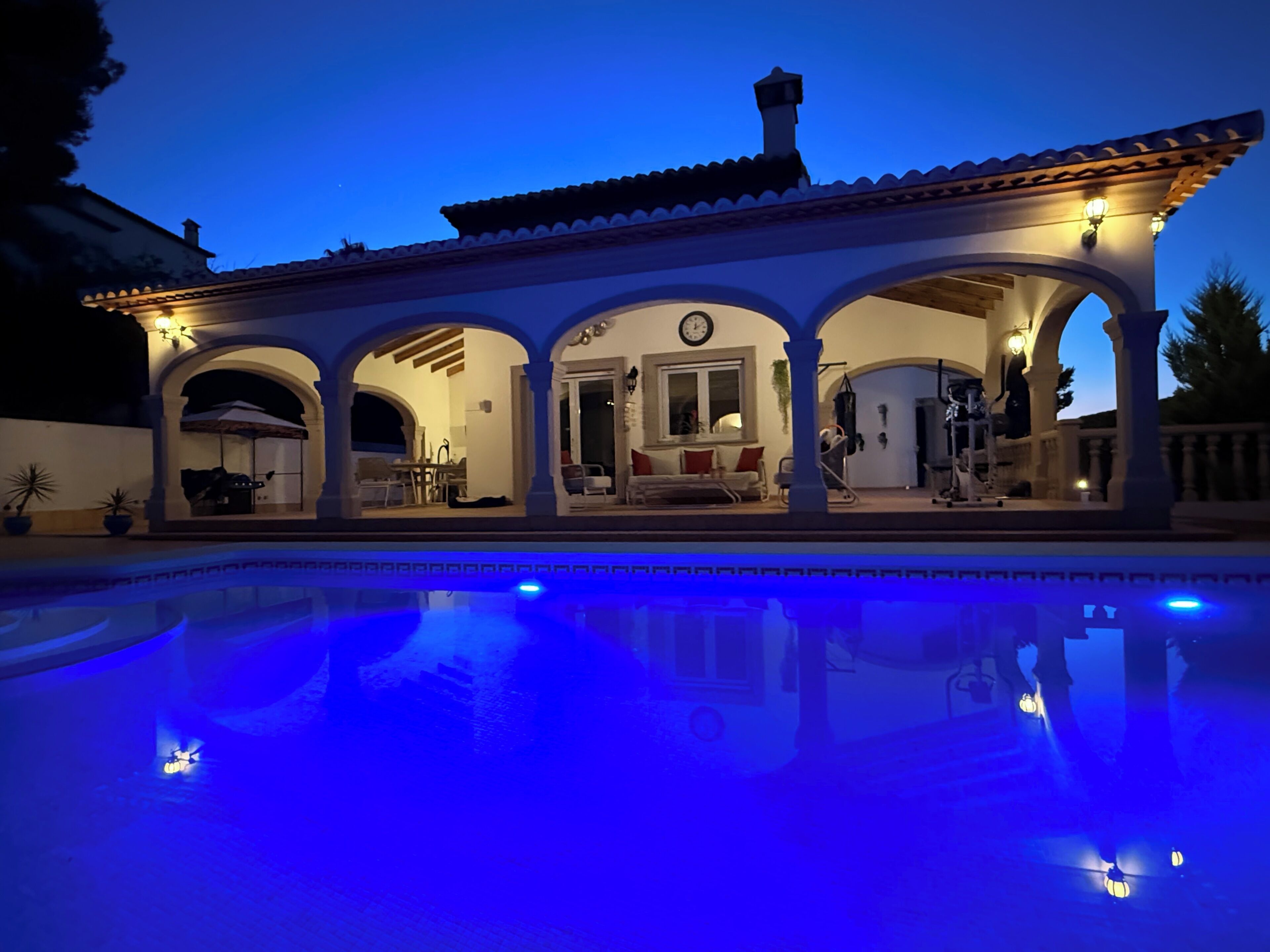 Una vila amb piscina, terrassa coberta, zona de menjador i saló.