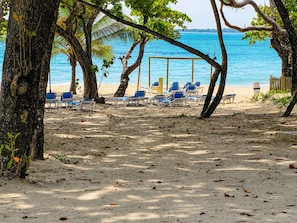 Une plage avec des chaises longues et une structure en bois.